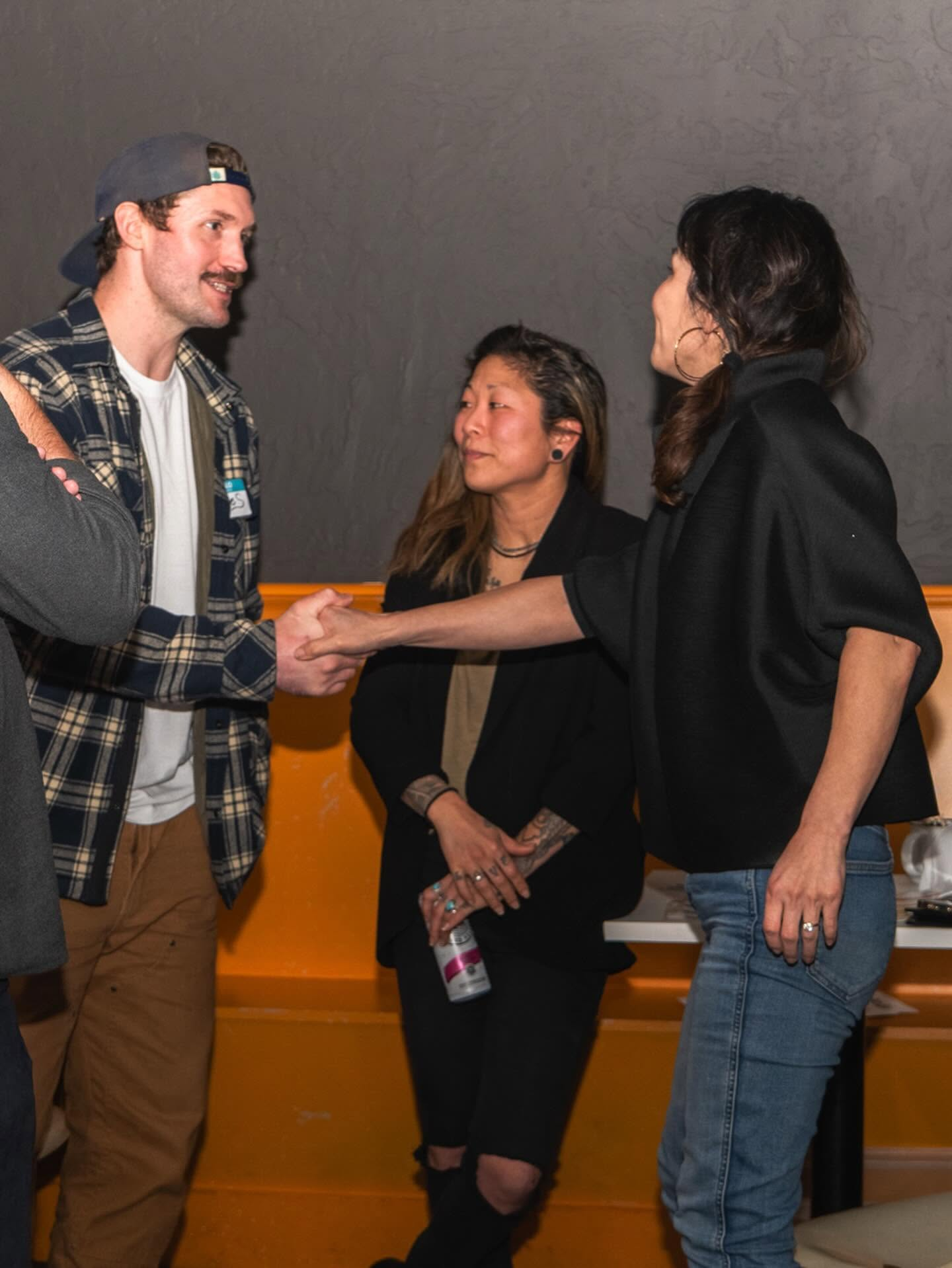Two people shaking hands at an outdoor brand gathering